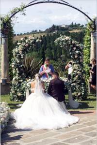 archi decorativi con fiori vicino agli sposi