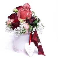 Composizione con rose e altri fiori e cuore di ceramica in scatola bianca rotonda