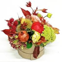 Composizione in scatola rotonda autunnale con fiori, ortensie e melograne