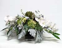 composizione con faleno, fiori di carciofo, ortensie e altri verdi devorativi in vaso di vetro quadrato